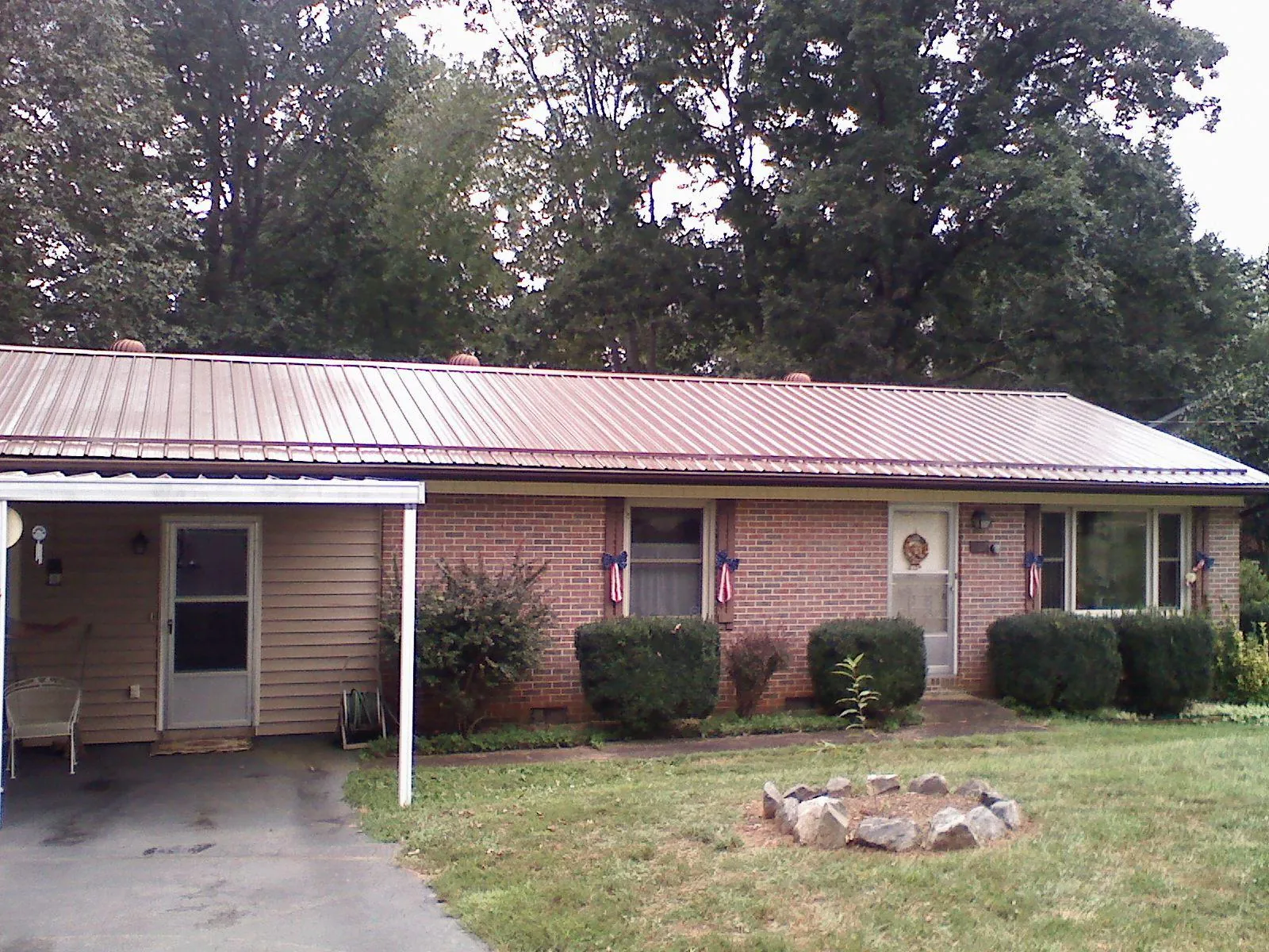 Bronze metal roof and carport on a brick ranch home — Roof Repair work by our crew in Camp Verde